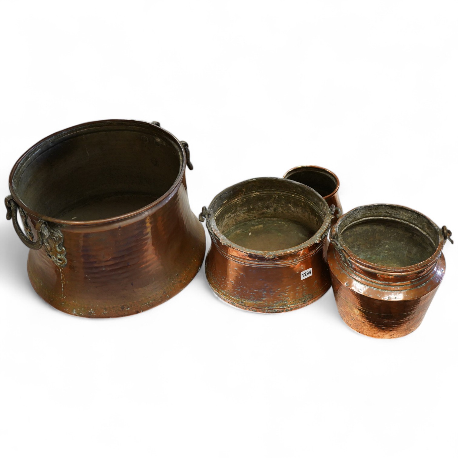 A collection of four copper vessels and another brass, largest 32cm